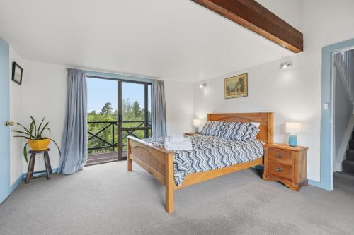 a bedroom with a bed and a balcony at The Wee Glen - Peaceful Country Retreat 2 bed in Bennetts