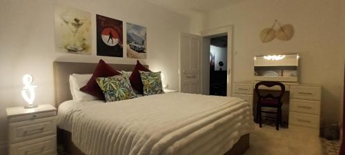 una camera da letto con un letto bianco e una sedia di Place of the Goddess a Damvillers