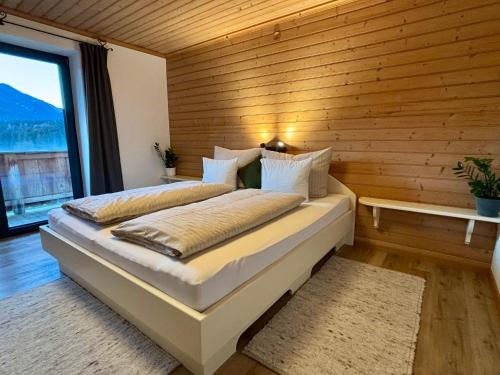 a bedroom with a large bed with a wooden wall at Landhaus Barbara in Kitzbühel