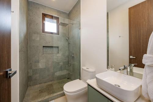 ein Badezimmer mit Toilette, Waschbecken und Dusche in der Unterkunft Hacienda Pinilla Vacation Rentals in Tamarindo