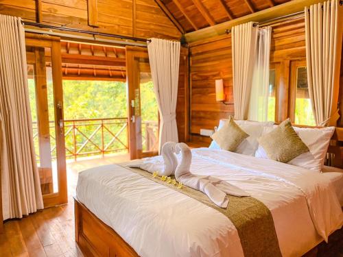 a bedroom with a bed with a swan on it at Wimala Farm House in Munduk