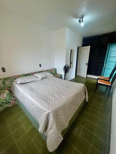 een slaapkamer met een bed en een stoel bij Residencial Brilha Mar in Capão da Canoa
