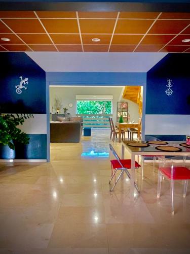 a dining room with a table and red chairs at Villa Rose Marie Chambres dhôtes au Calme et Grands Espaces in Le François