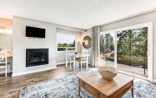 a living room with a fireplace and a table at Riverfront Condo with Amazing View - Downtown Bend in Bend