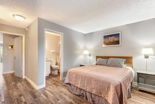 ein Schlafzimmer mit einem Bett und ein Badezimmer mit einer Toilette in der Unterkunft Riverfront Condo with Amazing View - Downtown Bend in Bend