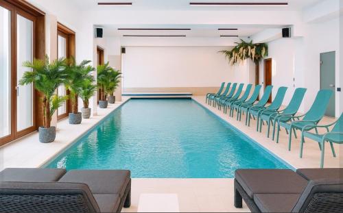 a pool in a room with chairs and tables at Hotel 5 HILLS DRAGASANI in Drăgăşani