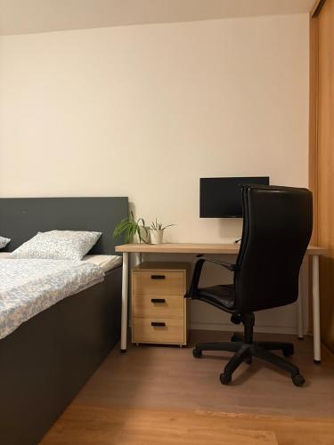 a bedroom with a desk with a computer and a bed at Cozy Self check-in Apartment in vibrant Ruzinov area, Komárnická 42, Bratislava in Bratislava