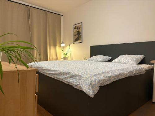 a bedroom with a large bed with a blue comforter at Cozy Self check-in Apartment in vibrant Ruzinov area, Komárnická 42, Bratislava in Bratislava