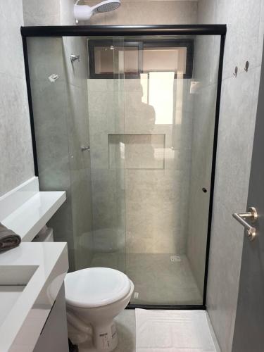 een badkamer met toilet en glazen douche bij Flat em Intermares Beach in Cabedelo