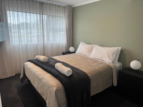 ein Schlafzimmer mit einem Bett, auf dem zwei Handtücher liegen in der Unterkunft Central Apartments in Rotorua