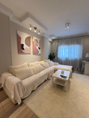 a living room with a white couch and a table at Queen Nefertari-Luxury Apartment Near Pyramids Giza in Cairo