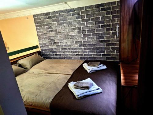 a bedroom with two beds and a brick wall at Apartment Cabin-Style in Belgrade