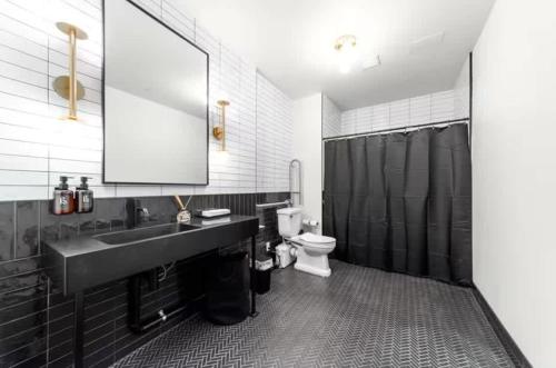 a bathroom with a sink and a toilet and a mirror at Symons Block Suite 5 in Spokane