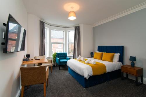 a bedroom with a bed and a desk and a chair at The Linden Leaf Rooms in Nottingham