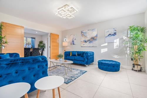 a living room with blue couches and a table at Long term stay Hot Tub EV Parking in West Bromwich