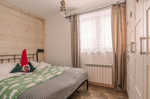 a bedroom with a bed with a santa hat on it at Tatra Prime in Bukowina Tatrzańska
