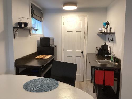 a room with a kitchen with a table and a sink at Bethel in Sherbrooke