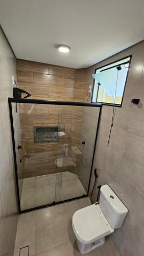 een badkamer met toilet en glazen douche bij Pousada do Barão in Lindóia
