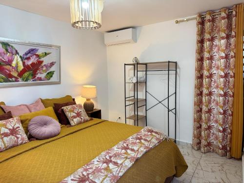 a bedroom with a bed with a yellow bedspread at Madikera Resort Beach Near in Saint-François