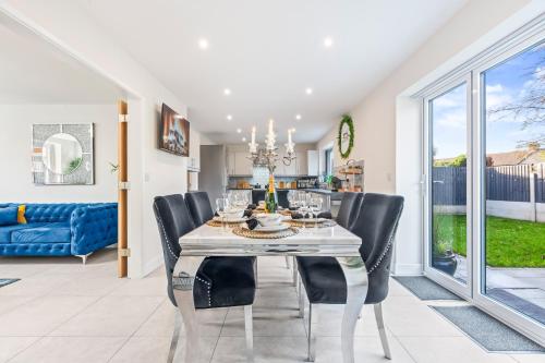 a dining room with a white table and black chairs at Long term stay Hot Tub EV Parking in West Bromwich