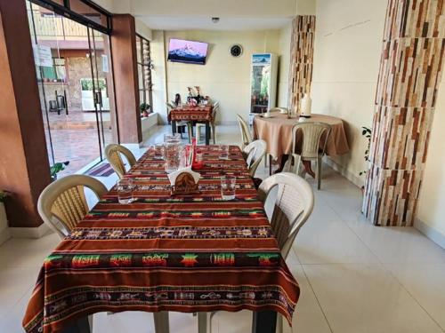 una sala da pranzo con un lungo tavolo con sedie di Hostal Edén a Torotoro