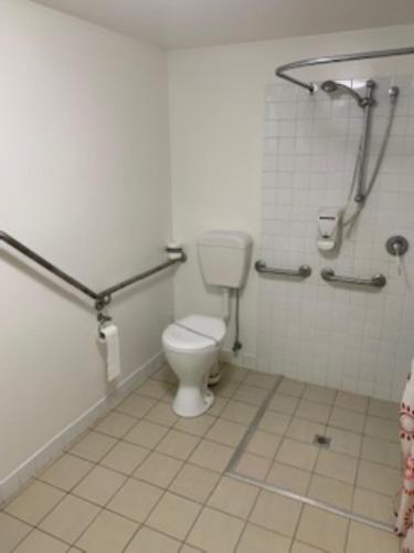 ein Bad mit WC in einem öffentlichen WC in der Unterkunft Queensport Tavern And Motel in Brisbane
