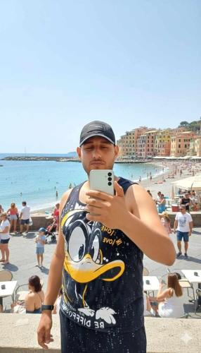a man standing on the beach looking at his cell phone at السنطه in Mīt al Layth