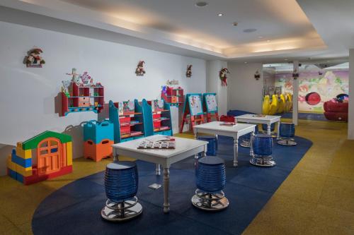 a childrens play room with tables and play equipment at The Sakala Resort Bali All Suites in Nusa Dua