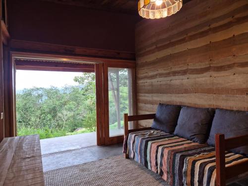 a bedroom with a bed and a sliding glass door at Casa Solar in São Bento do Sapucaí