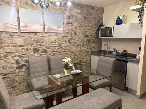 a kitchen with a table and chairs and a stone wall at Firenze en ValQuirico in Santeagueda