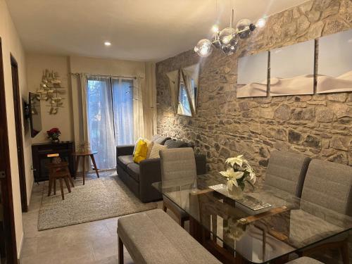 a living room with a couch and a stone wall at Firenze en ValQuirico in Santeagueda