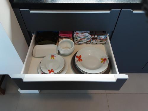 twee borden en kommen in een lade van een koelkast bij Quarto e banheiro privativo pet friendly in Garopaba