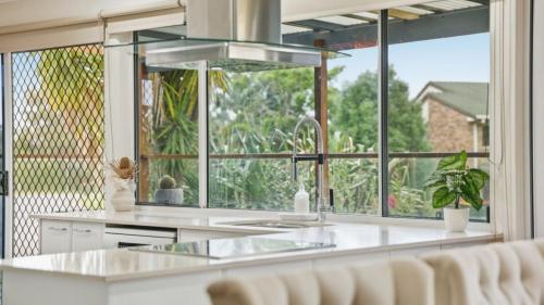 une cuisine avec une grande fenêtre et un comptoir blanc dans l'établissement Station on Pearce, à Coffs Harbour