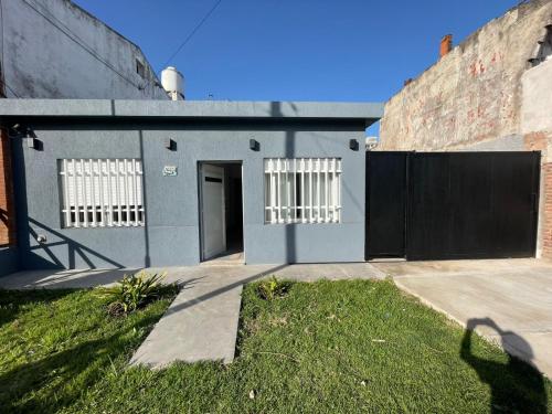 een grijs gebouw met witte ramen en een deur bij Mansilla playa in Mar del Plata