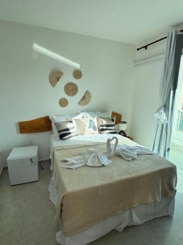 een slaapkamer met een bed met twee handdoeken erop bij Pousada Vila Mar Japaratinga in Japaratinga