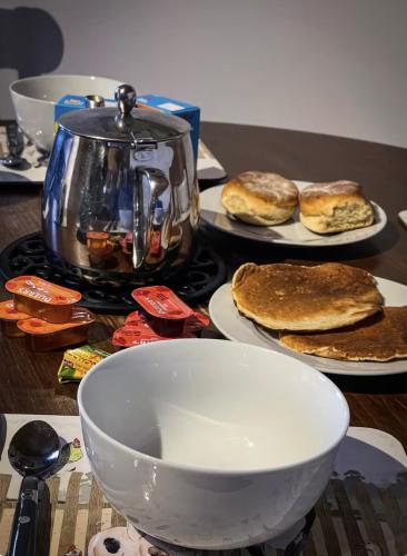 a table with plates of pancakes and a tea kettle at Glenariff Forest Getaway in Glenariff