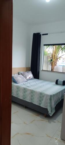 een bed in een kamer met een raam bij Matinhos balneário Riviera in Matinhos