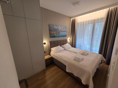 ein kleines Schlafzimmer mit einem Bett und einem Fenster in der Unterkunft Omega Lake Family 1 in Olsztyn