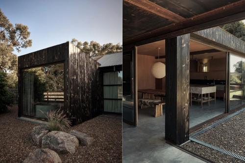 een modern huis met glazen wanden en een spiegel bij Ross Farm - Dairy in Meeniyan