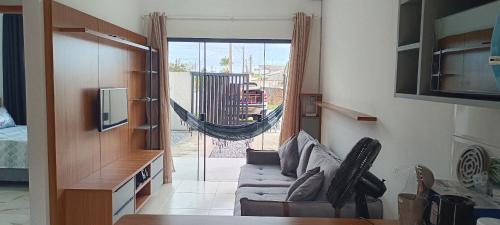een woonkamer met een bank en een glazen schuifdeur bij Matinhos balneário Riviera in Matinhos