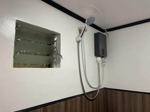 a shower in a room with a mirror at Nayon Inn in El Nido