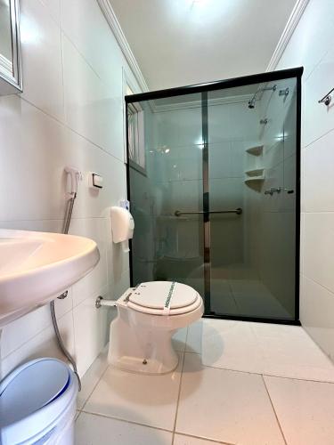 a bathroom with a toilet and a glass shower at Pousada dos Esquilos in Campos do Jordão
