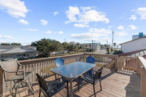 a patio with a table and chairs on a deck at Elegant Huge Ocean View 4 King, Private Pool, Huge Yard, Enormous Game Garage, BBQ, & Rooftop Deck in Myrtle Beach