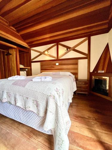 a bedroom with a bed and a fireplace at Pousada dos Esquilos in Campos do Jordão