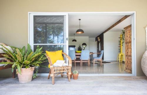 a patio with chairs and a table with a yellow pillow at Honeybird Hideaway in Crabbes Creek