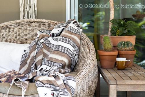 a blanket on a wicker chair next to a table at Honeybird Hideaway in Crabbes Creek