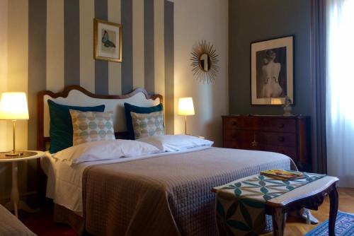 ボローニャにあるAy Home B&Bのベッドルーム1室(ベッド1台、テーブル、ランプ2つ付)