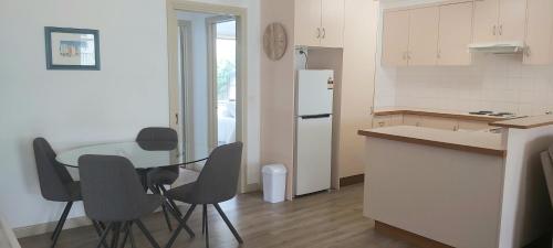 een keuken met een tafel, stoelen en een koelkast bij Margarets Lane in Warrnambool