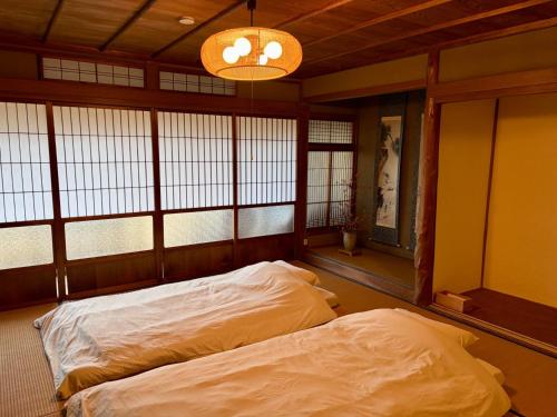 una stanza con due letti in una stanza con finestre di Tasogare 