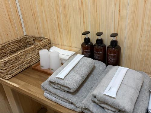 un tavolo di legno con due bottiglie di sapone e asciugamani di Tasogare 